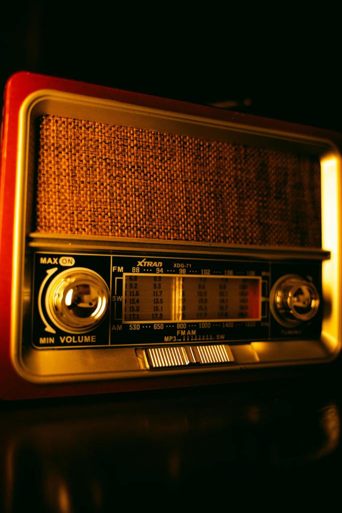 Close-up of an antique radio with warm golden lighting, showcasing retro knobs and intricate details.