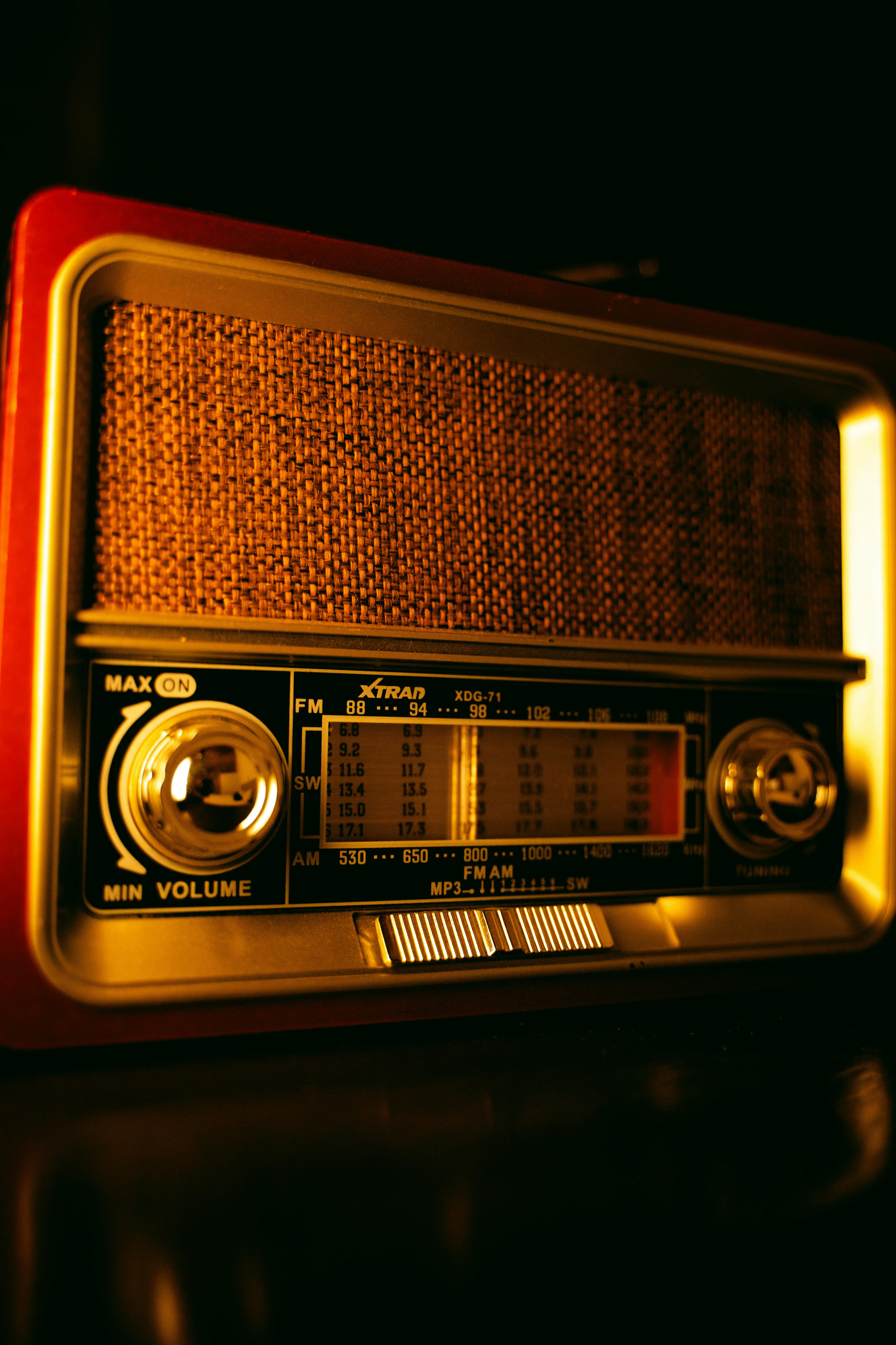 Close-up of an antique radio with warm golden lighting, showcasing retro knobs and intricate details.