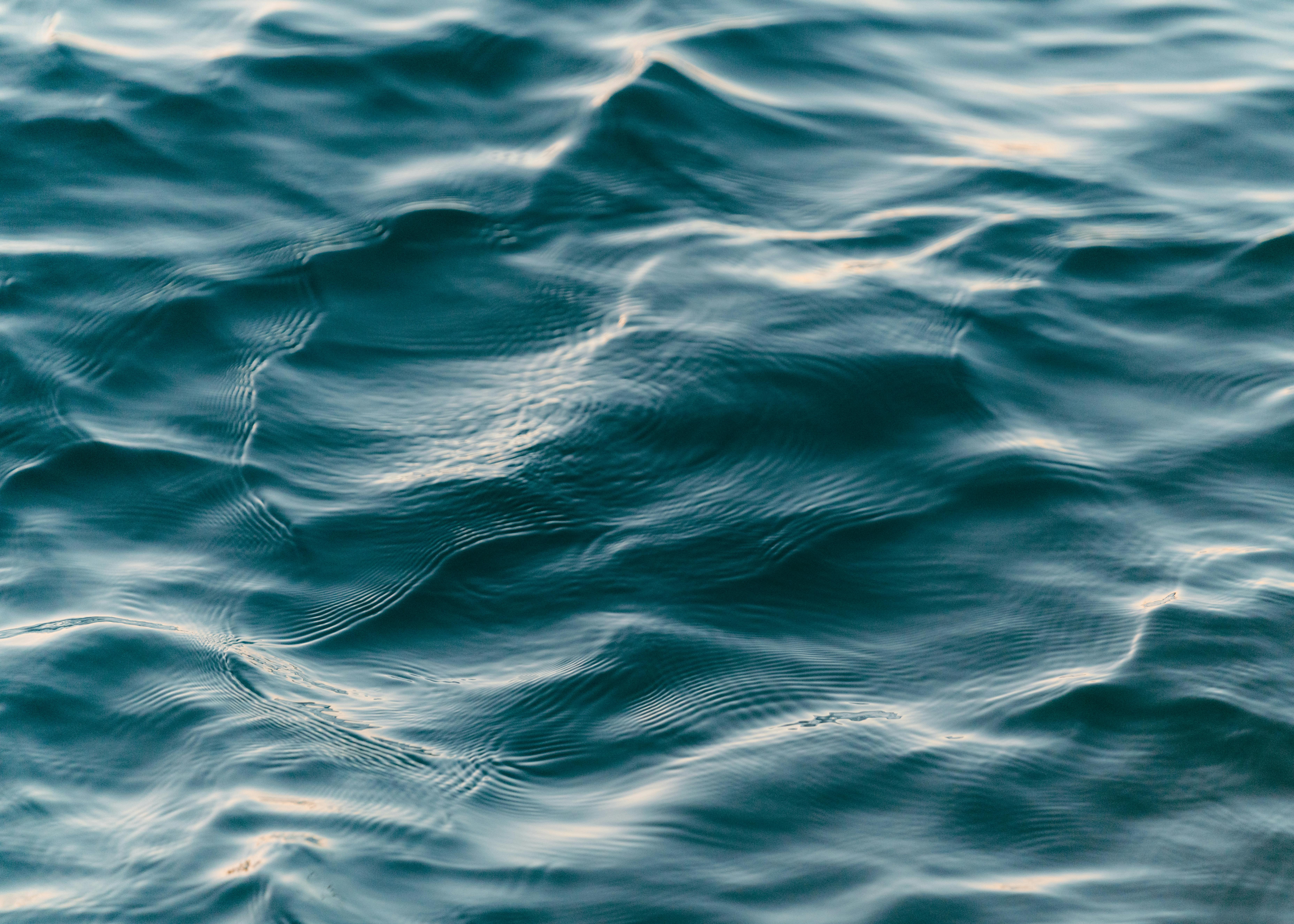Calm blue ocean waves creating a soothing ripple texture, ideal for backgrounds.